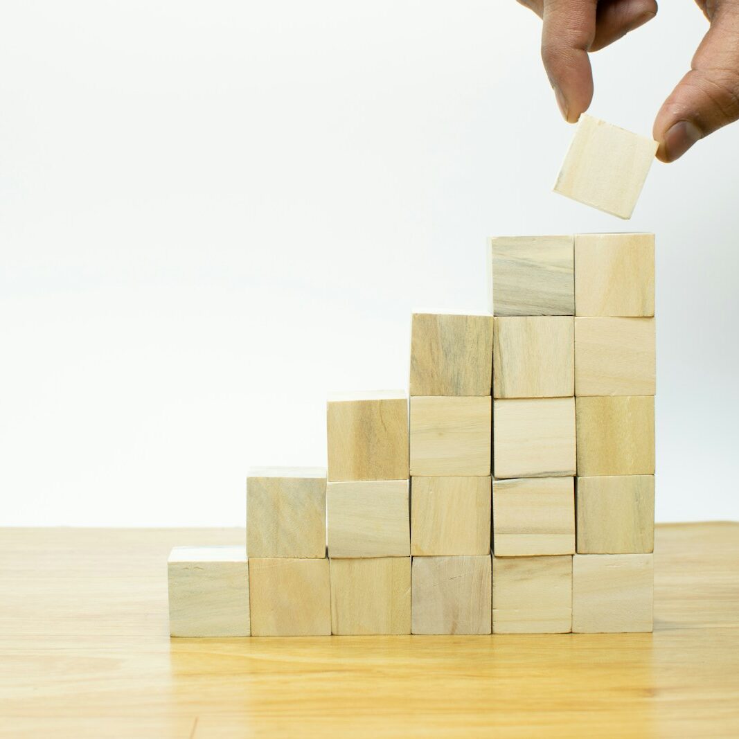 A person placing a piece of wood into a pyramid